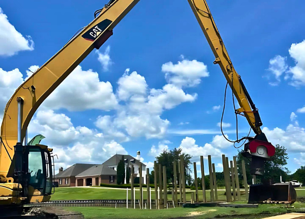 excavator installing pilings
